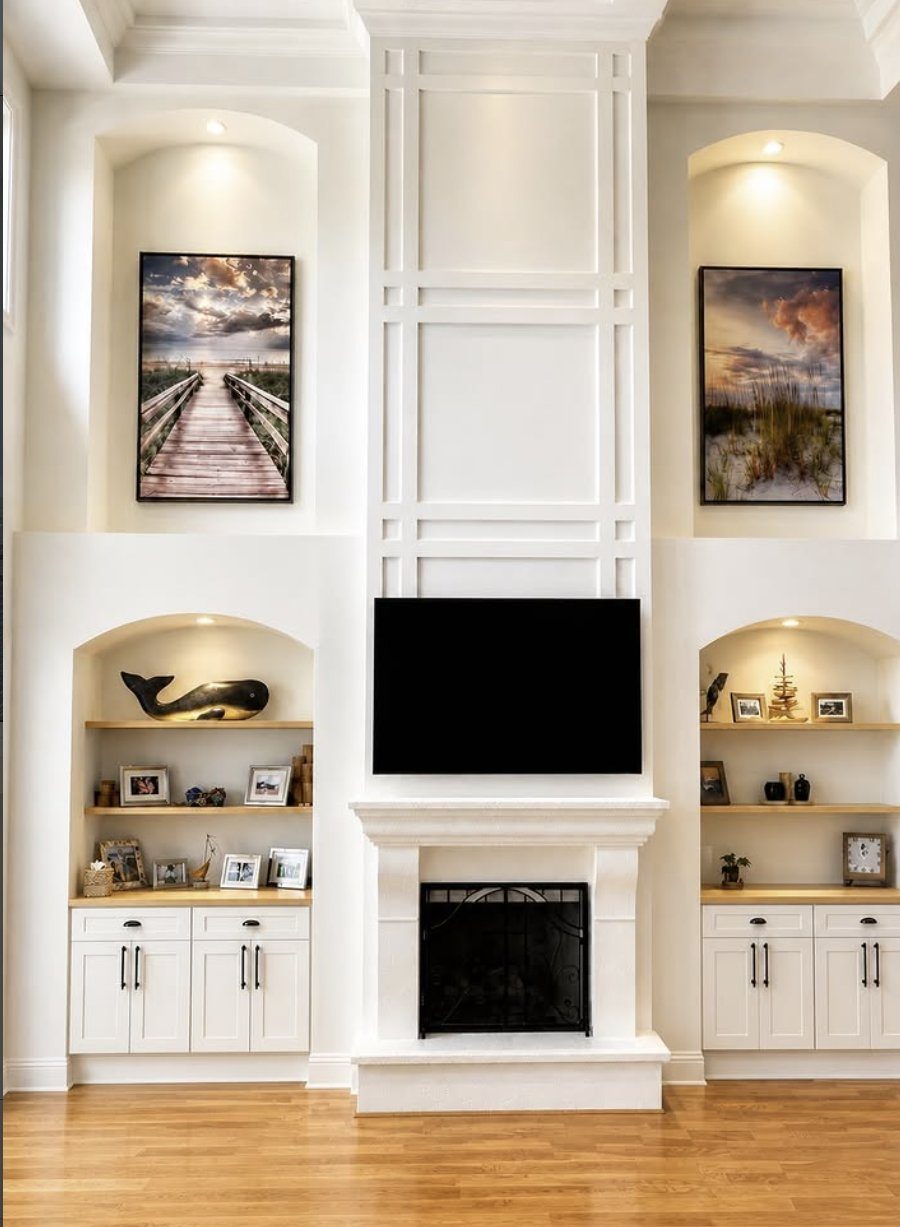 Built-in cabinetry and arched display niches framing a fireplace and television